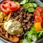 Burger bowl with fresh greens, grilled chicken, colorful vegetables, and a drizzle of dressing